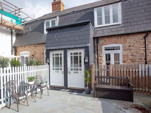 a house with a white fence and a patio at 1 Perfectly located stylish, comfortable apartment in Sidmouth