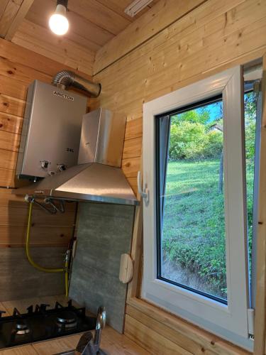 a kitchen in a tiny house with a window at Ramona in Ambrolauri