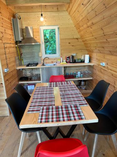 a dining room with a table and chairs in a cabin at Ramona in Ambrolauri