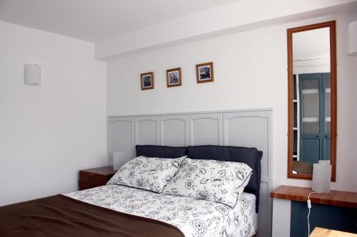 um quarto branco com uma cama e um espelho em Florence Park Flat em Oxford