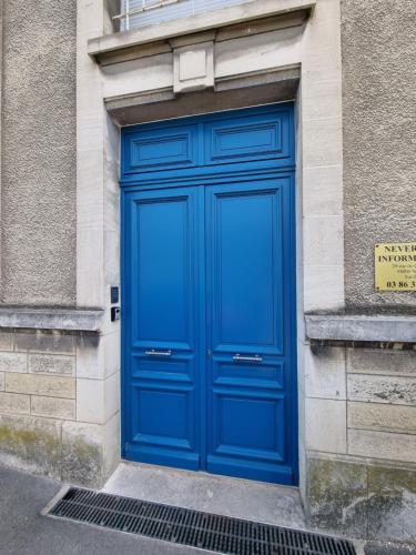 een blauwe deur aan de zijkant van een gebouw bij Le St Gildard in Nevers
