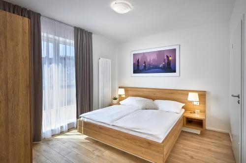 ein Schlafzimmer mit einem Bett und einem großen Fenster in der Unterkunft DownTown Suites Belohorska in Prag