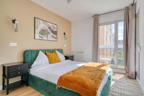 une chambre avec un lit vert et une fenêtre dans l'établissement Le Nuancé - À deux pas de Paris - 325B, à Rueil-Malmaison