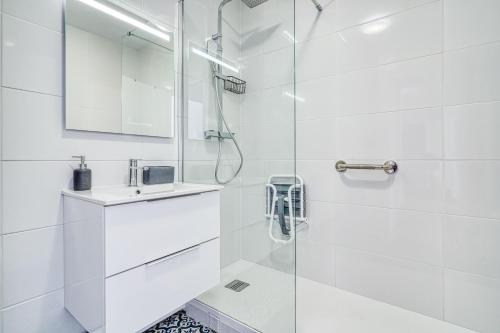 une salle de bain blanche avec une douche et un lavabo dans l'établissement Le Nuancé - À deux pas de Paris - 325B, à Rueil-Malmaison