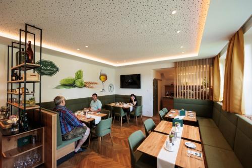 a dining room with people sitting at tables in a restaurant at Biergasthof Riedberg in Ried im Innkreis