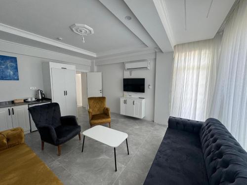 a living room with a couch and chairs and a tv at The Dalaman Suites & Pansiyon in Dalaman