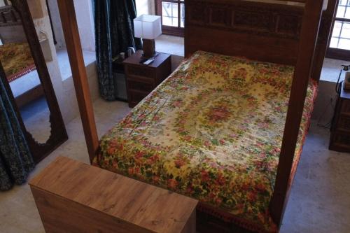 Schlafzimmer mit einem Bett, einem Tisch und einem Spiegel in der Unterkunft Hercai Butik Otel in Midyat
