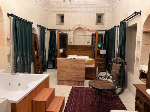 a bathroom with a tub and a sink and a bed at Hercai Butik Otel in Midyat