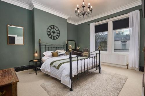a bedroom with a bed and a clock on the wall at Flat 5 Minutes From The Beach - Street Parking in Whitley Bay