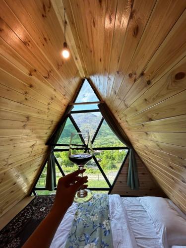 a person holding a glass of wine in a tree house at Ramona in Ambrolauri