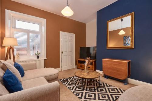 a living room with a couch and a tv at Flat 5 Minutes From The Beach - Street Parking in Whitley Bay