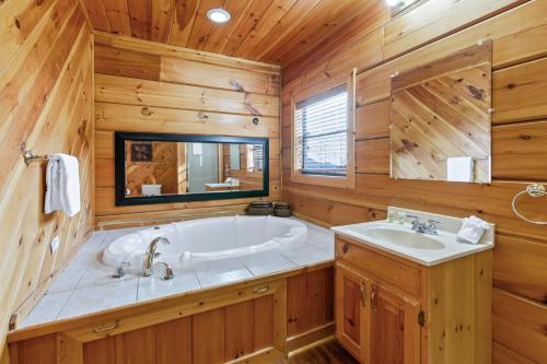 ein großes Bad mit einer Badewanne und einem Waschbecken in der Unterkunft Grand View Lodge in Pigeon Forge