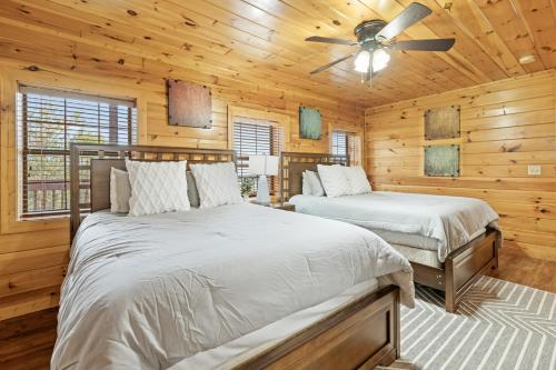 1 Schlafzimmer mit 2 Betten und einem Deckenventilator in der Unterkunft Grand View Lodge in Pigeon Forge