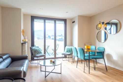 un salon avec un canapé, des chaises et une table dans l'établissement LE BEAU MARCY - Contemporary city centre flat, à Annecy