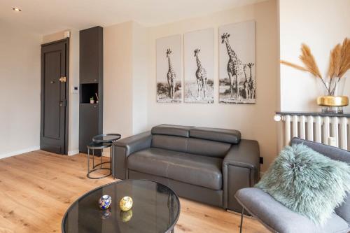 un salon avec un canapé et une table dans l'établissement LE BEAU MARCY - Contemporary city centre flat, à Annecy