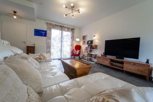 sala de estar con sofá y TV de pantalla plana en Le Doux Paradis - Maison 4 Chambres en Doussard
