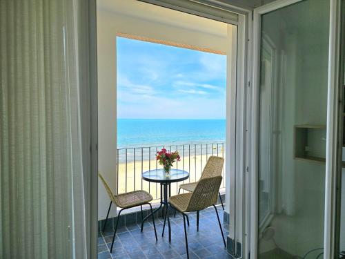 a balcony with a table and chairs and the ocean at Sea Vista Apartment in Durrës