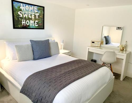a bedroom with a bed and a desk and a mirror at Prospect Apartment, 3 Guests, Free Parking & Wi-Fi in Reading