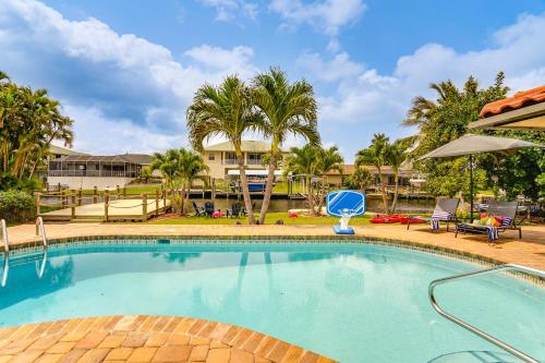 a swimming pool with palm trees and a resort at Waterfront Fort Myers Home Private Pool and Dock in Fort Myers