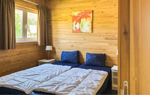 een slaapkamer met een bed en twee blauwe kussens bij Lovely Home In Heel With Wifi in Heel