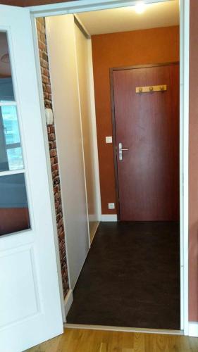un couloir avec une porte et un mur en briques dans l'établissement Appartement 27 m2 et parking, à Rennes