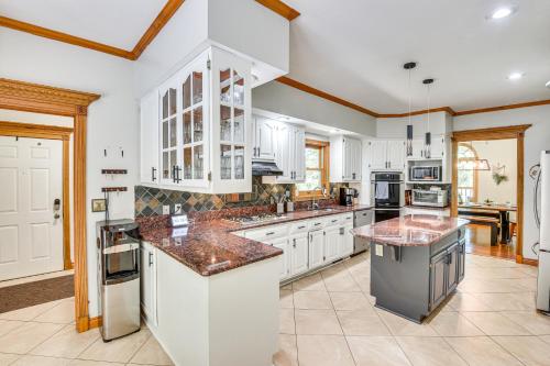 a large kitchen with white cabinets and granite counter tops at Huge Family Home with Pool - 13 Mi to Lake Michigan! in LaPorte