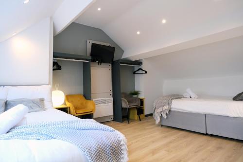 a bedroom with two beds and a television in it at Breckfield House by Serviced Living Liverpool in Liverpool