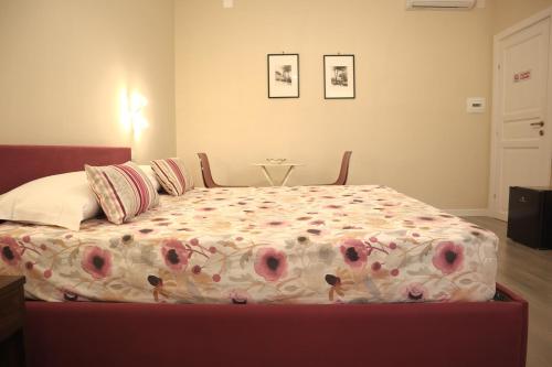 a bedroom with a bed with a floral comforter at Villa Gagliozzi in Ercolano