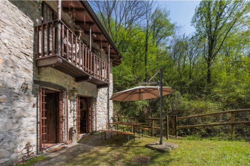 a patio with an umbrella next to a building at Antico Mulino Baderem in Sorisole