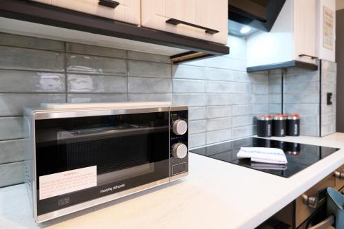 a microwave oven sitting on a counter in a kitchen at Breckfield House by Serviced Living Liverpool in Liverpool