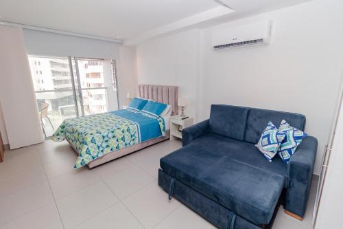 een woonkamer met een bank en een bed bij Hermoso Apartamento tipo Loft en Rodadero Santa Marta in Santa Marta