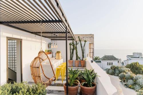 d'un balcon avec une table, des chaises et des plantes. dans l'établissement Villa Augustine, à Tanger
