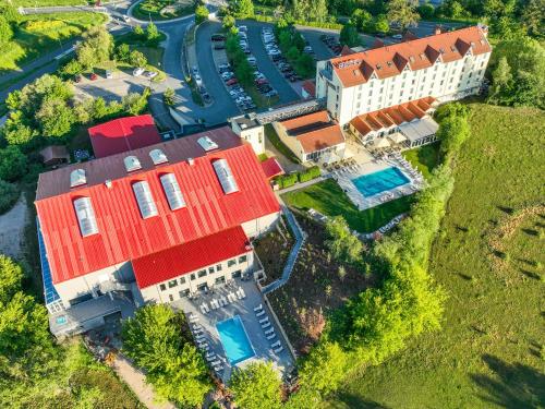 una vista aérea de una casa grande con techo rojo en FAIR RESORT All Inclusive Wellness & Spa Hotel Jena en Jena