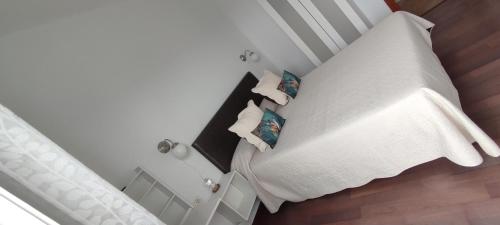 a bedroom with a white bed with two pillows at Finca Rural La Casa Verde Shalom Tenerife in Las Lagunas
