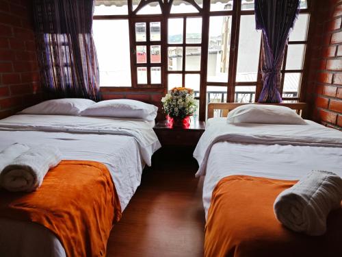 En eller flere senge i et værelse på Garden House Hostal