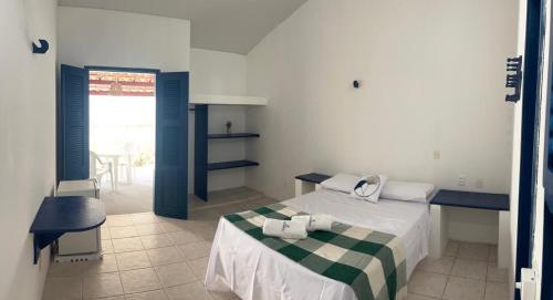 - une chambre dotée d'un lit avec une couverture verte et blanche dans l'établissement Pousada Palamós Uruaú, à Beberibe