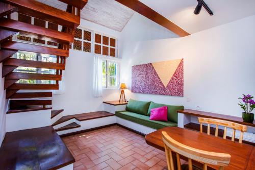 a living room with a green couch and a table at Hotel Aldeia de Sahy in Barra do Sahy