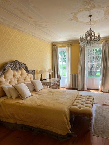 - une grande chambre avec un grand lit et un lustre dans l'établissement Hôtel de Margaux, à Margaux