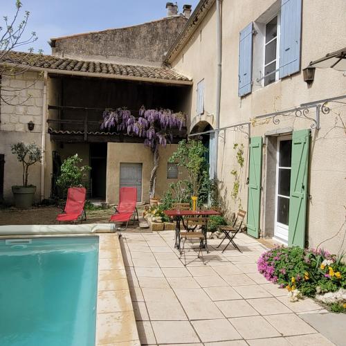 un patio avec une table et des chaises et une piscine dans l'établissement Maison de village du XVII siècle en Camargue, à Le Cailar