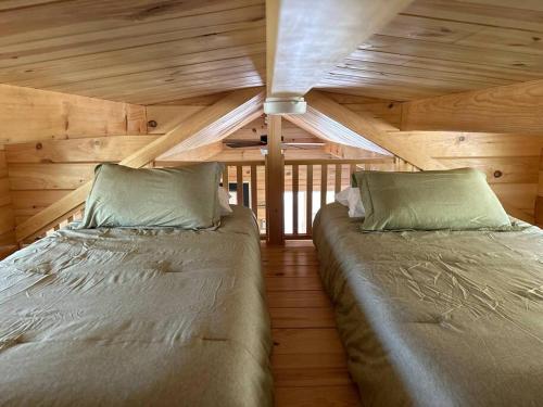a bedroom with two beds in a log cabin at The Bellefonte Campground in Bellefonte