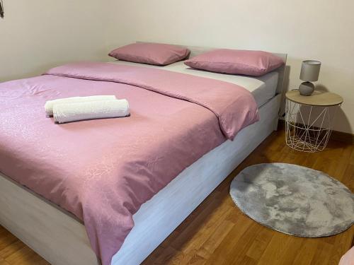 a bedroom with two beds with pink and white sheets at Apartment Helena Airport in Podgorica