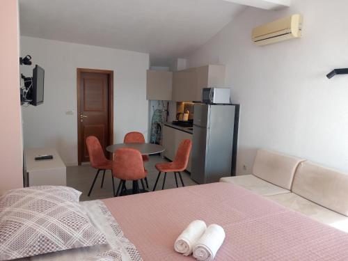 um quarto com uma cama, uma mesa e cadeiras em Mitan apartman em Tučepi