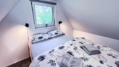 Habitación pequeña con cama y ventana en Domeček u Brna, klid & wi-fi, en Bílovice nad Svitavou