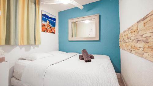 une chambre avec deux lits et un miroir au mur dans l'établissement Le PTIT ZLATAN, Vue Exceptionnelle sur la Mer, à Sainte-Maxime