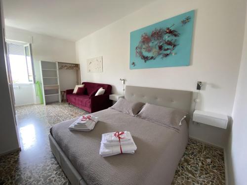 ein Schlafzimmer mit einem Bett und einem roten Sofa in der Unterkunft Rossocorallo Rooms in Alghero