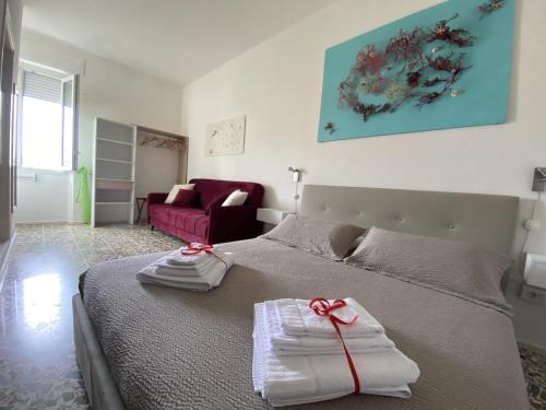 a bedroom with a bed with towels on it at Rossocorallo Rooms in Alghero