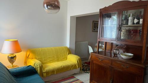 sala de estar con silla amarilla y armario en Pianchehome, en Cappella Maggiore