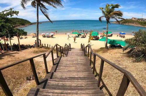 una scala in legno che conduce a una spiaggia con persone di Apartamento confortável no centro de Guarapari a Guarapari