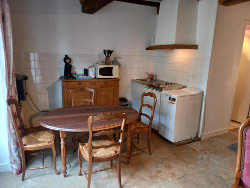 une petite cuisine avec une table et un micro-ondes dans l'établissement Maison studio village médiéval, à Mont-Saint-Jean
