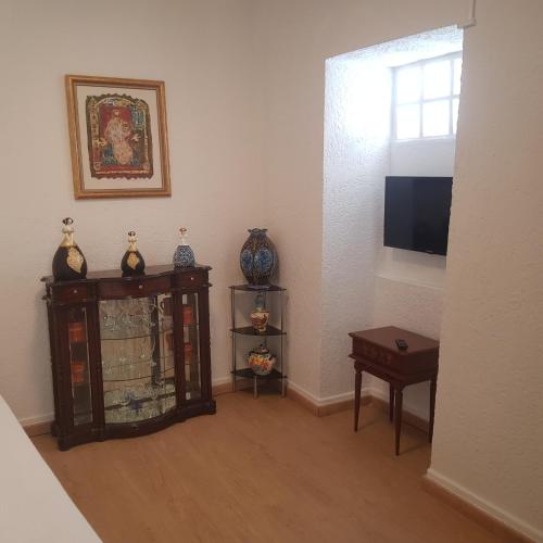 a room with a tv and some vases on a shelf at José Domingos in Belmonte